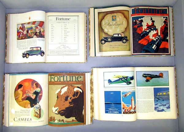 middle display case, showing bound copies of Fortune, opened to various covers andillustrations, mainly with a travel theme