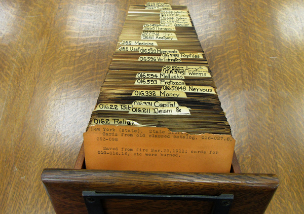 card catalog drawer with cards singed by the 1911 fire
