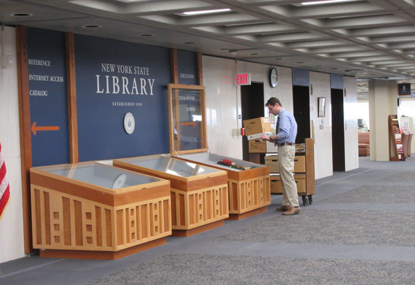 A staff member installing an exhibit on the public floor