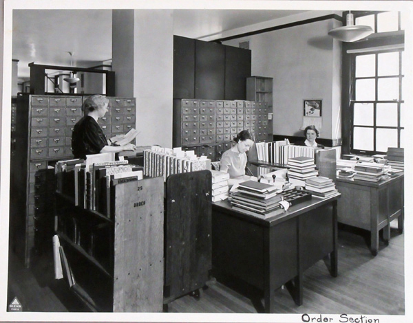 Order section in the 1940s, with one woman standing and two others at desks