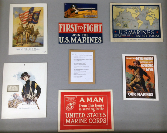 Left diplay case, with recruitment posters for the US Marines.