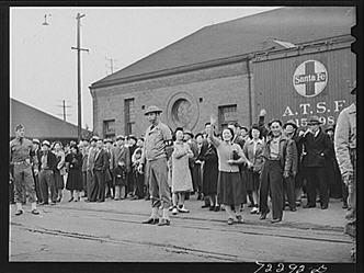 Black-and-white photo of Japanese-Americans at a station in Santa Fe, NM.